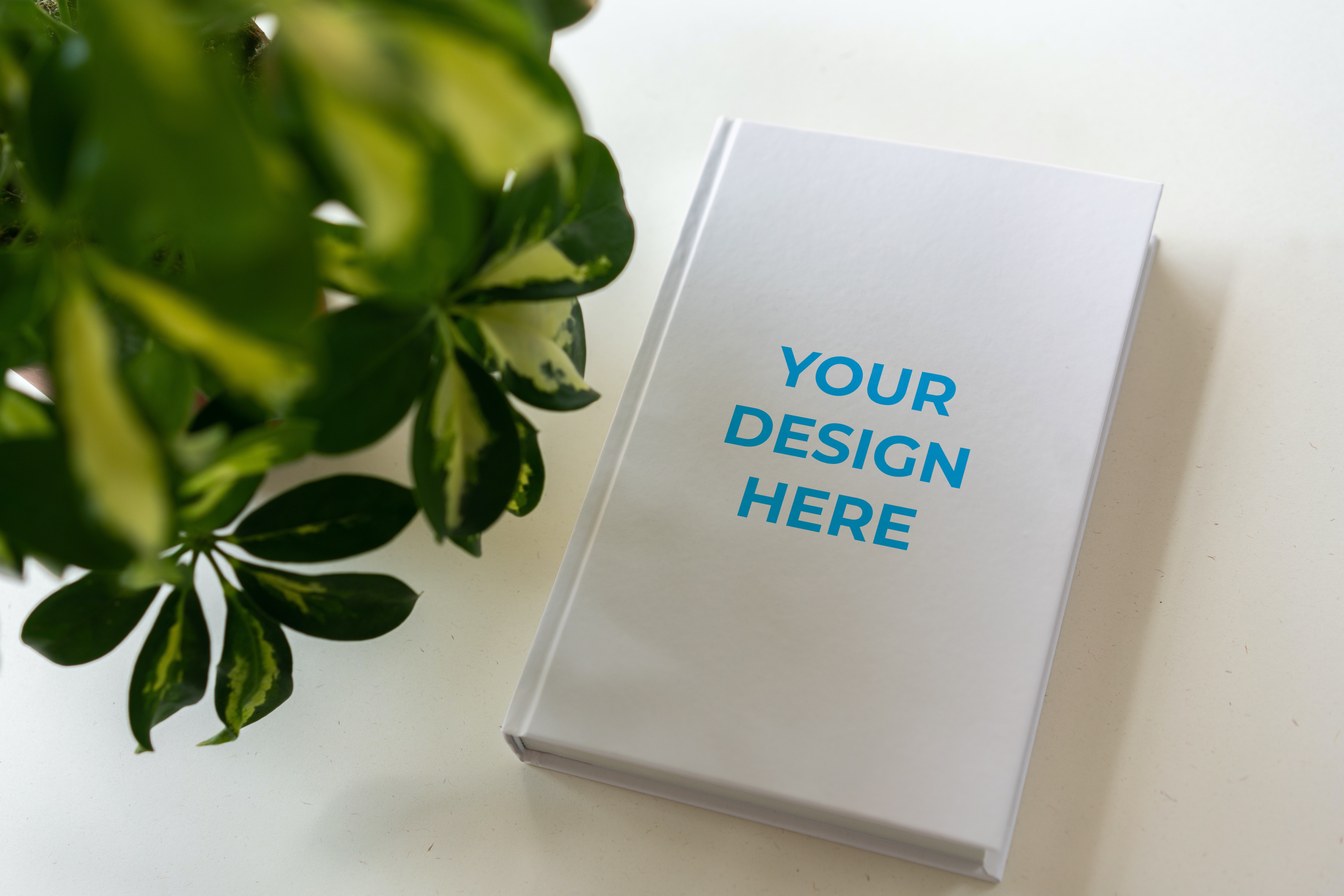 Free Book hardcover near the flower Mockup generator